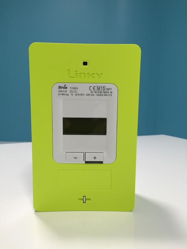 Front view of the Linky meter. It's a green rectangular plastic box, 20cm wide and 12cm tall, with a small text display and two navigation buttons in the middle.